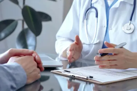 Lekarz uspokaja pacjenta z kancerofobią, tłumacząc wyniki badań.